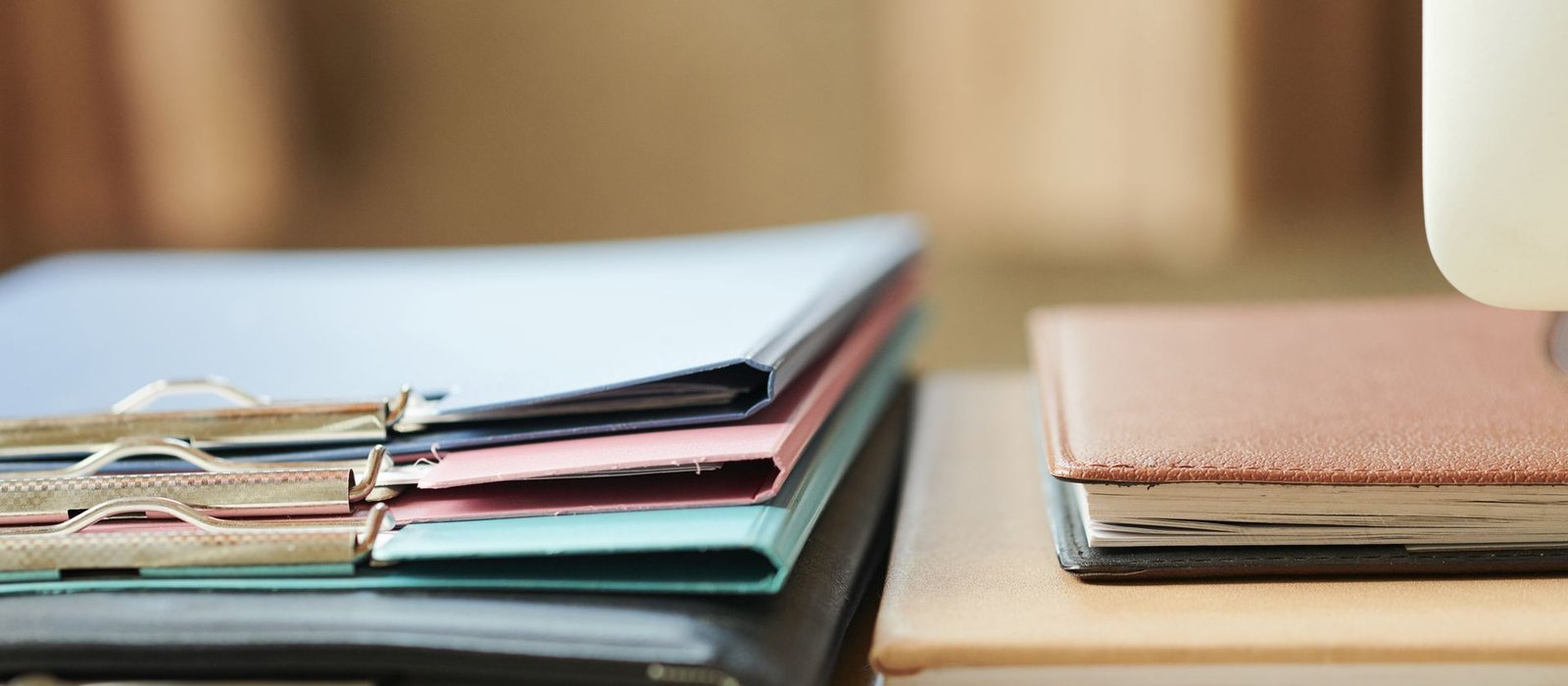 Folders and planners on an office desk, representing research and documentation